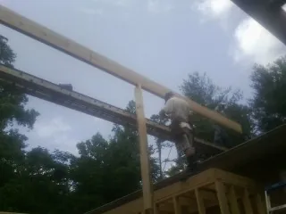 Carpenter setting a ridge beam over a new addition frame — Ice Dam Removal by Roofing Brothers in Red Hill