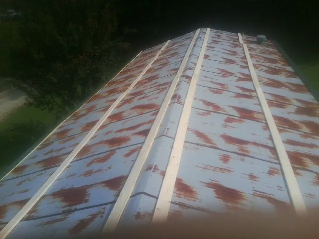 Rusted metal roof panels with new wood purlins before replacement — Storm Damage Roof Repair in Red Hill by Roofing Brothers