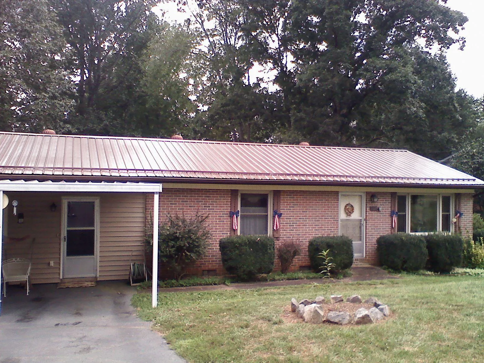 Bronze metal roof and carport on a brick ranch home — Roof Repair work by our crew in Red Hill