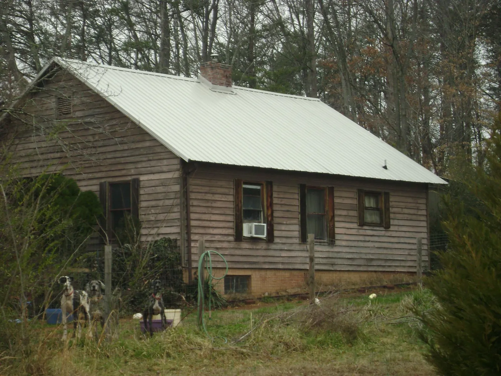 White metal roof on an old wood sided farmhouse, from a Metal Roof Installation job in Red Hill